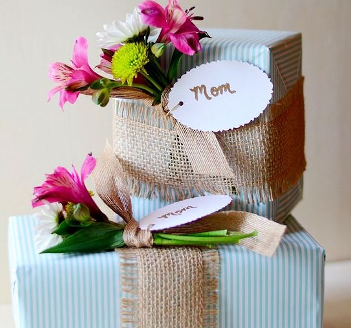 exemple de boite cadeau carton enveloppée de papier cadeau à rayures bleues et blanches et bouquet de fleurs