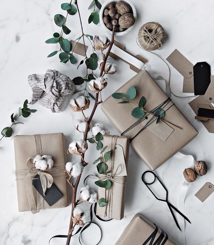 boite emballage cadeau en papier kraft avec des etiquettes cadeau, branches verte et coton naturel, idée emballage classique