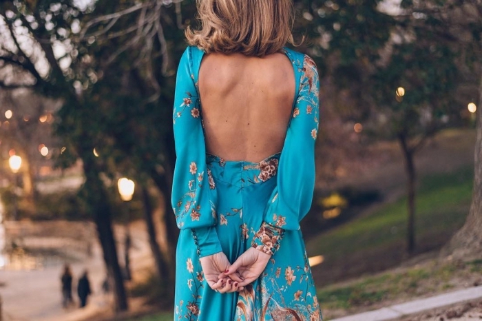 combinaison soirée cocktail, coupe de cheveux mi-longs de couleur châtain foncé, combinaison bleue à motifs floraux marron