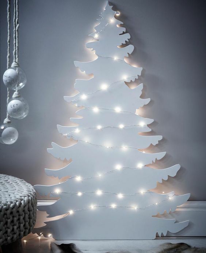 décoration de noel à fabriquer pour adultes, sapin blanc illuminé par des guirlandes à la lumière blanche, pour installer contre un mur 