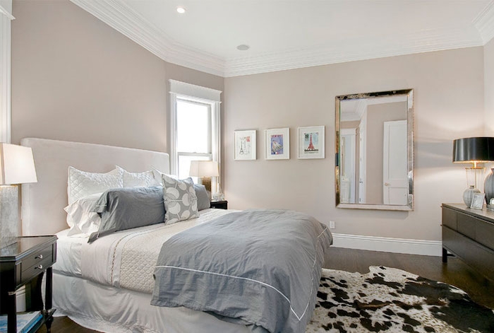 chambre a coucher peinture taupe clair, parquet marron, linge de lit blanc et bleu, tapis peau animale blanc et marron, meuble marron