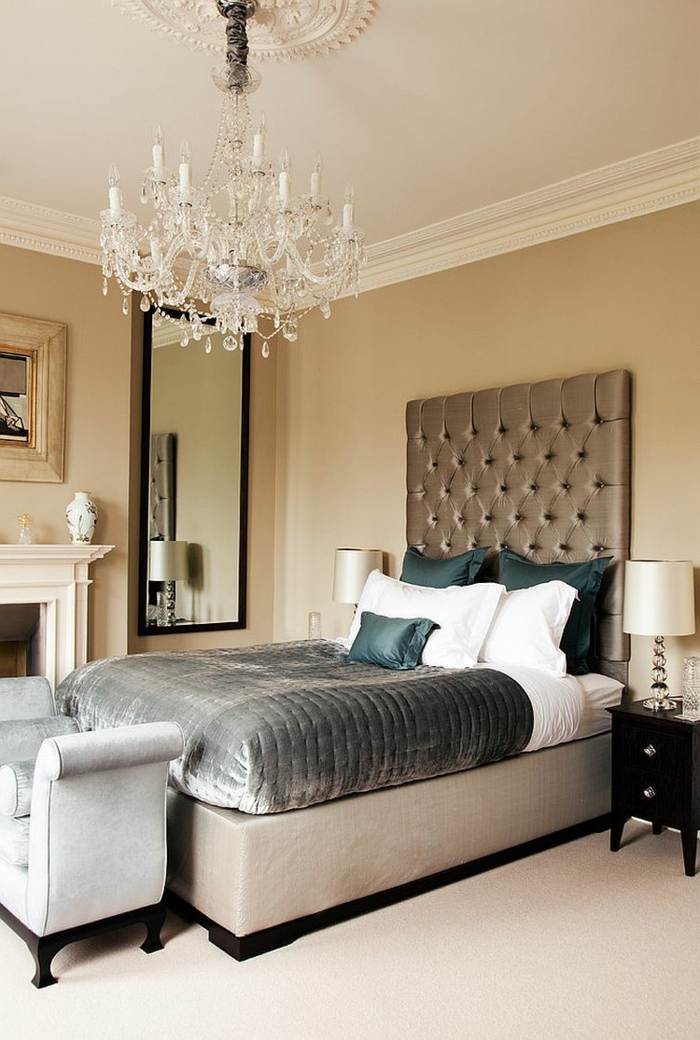 chambre baroque, un lit gris taupe, plafonnier en cristal, banquette de lit grise, cheminée décorative