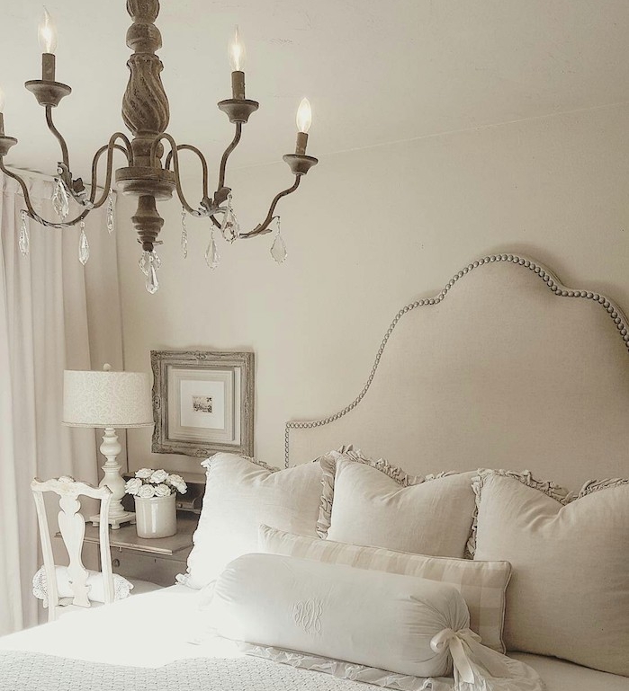 chambre gris clair à murs blancs, lustre élégant, linge de lit gris et blanc, lustre élégant style baroque, chaise blanche et bureau bois