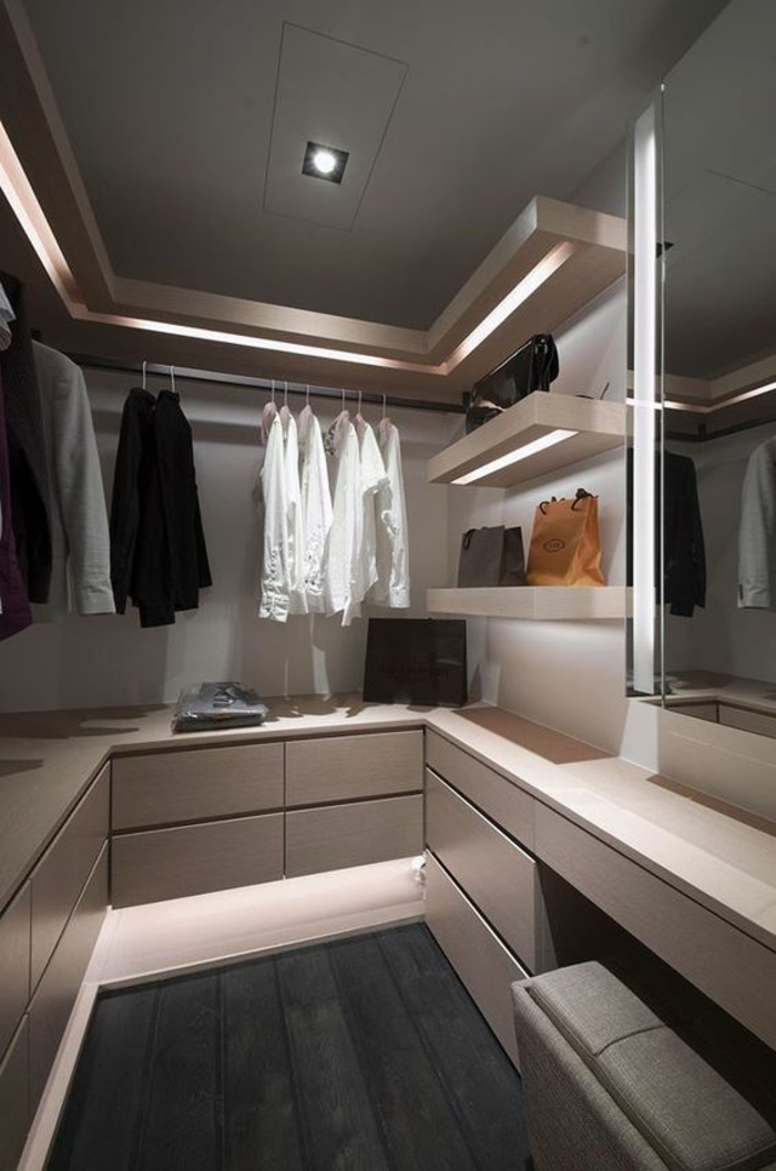 comment bien ranger sa chambre espace homme avec les vestes et les chemises, meubles au design minimaliste en couleur beige et des lignes de leds lumineux qui délivrent une lumière discrète