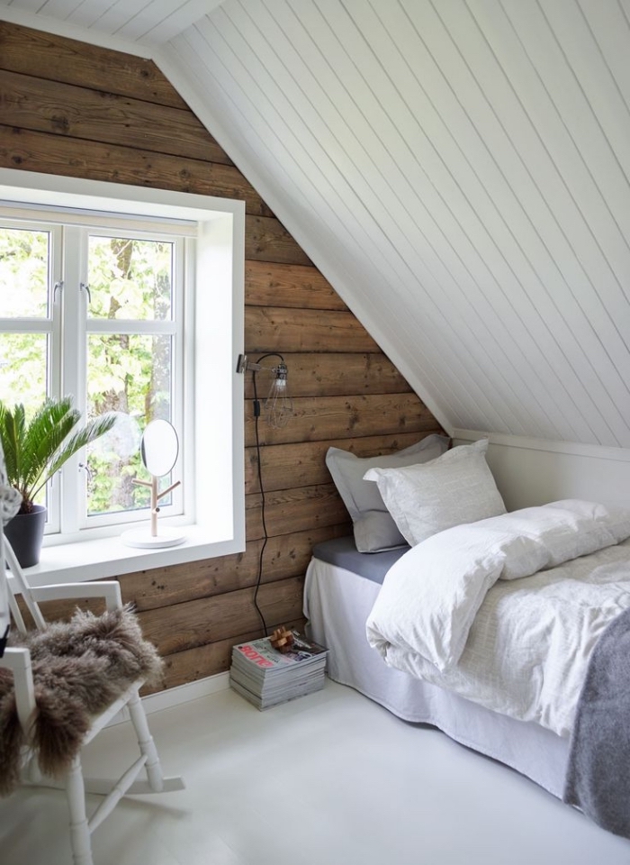 piece mansardée, chambre à coucher sous pente avec murs en bois foncé et plafond en bois peint en blanc