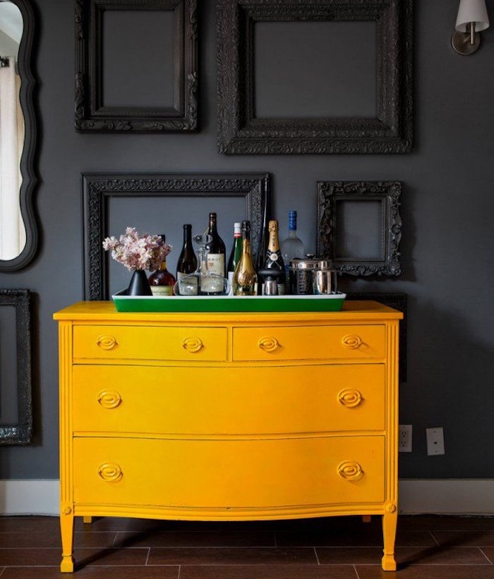 peinture pour meuble, commode jaune vintage avec un mur de fond gris anthracite décoré de cadres noirs