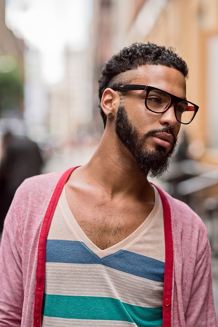 une coupe hipster afro avec dégradé haut bien démarquée et barbe déconectée