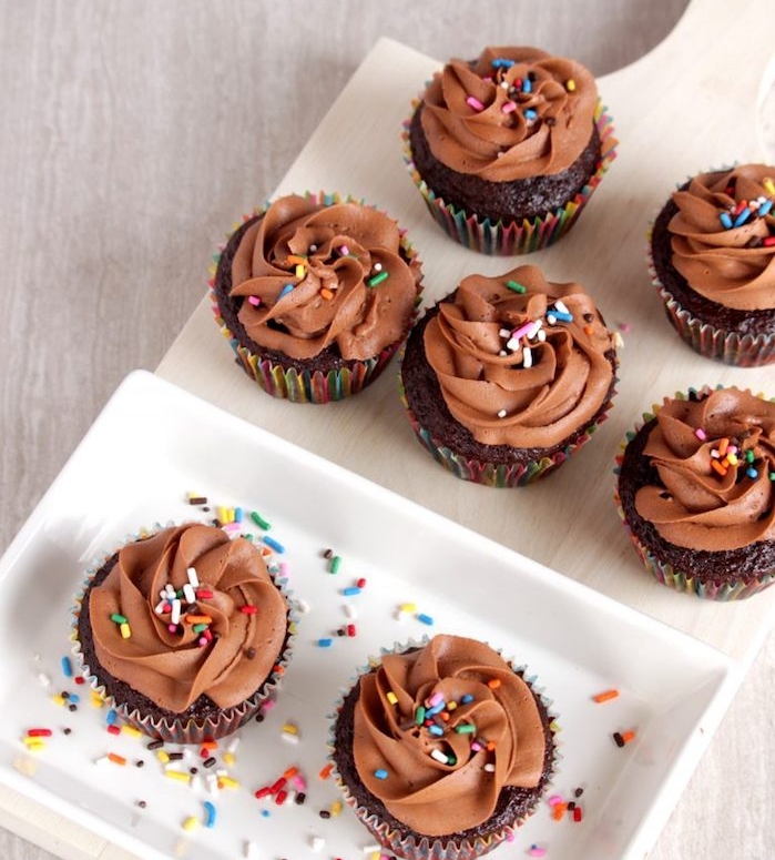cupcakes au chocolat avec glacage au chocolat et beurre et deçoration de vermicelles colorées dessus