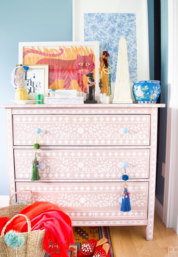 customiser meuble ancien, commode relookée au pochoir, motifs floraux blancs sur une peinture de fond rose, objets decoratifs orientaux