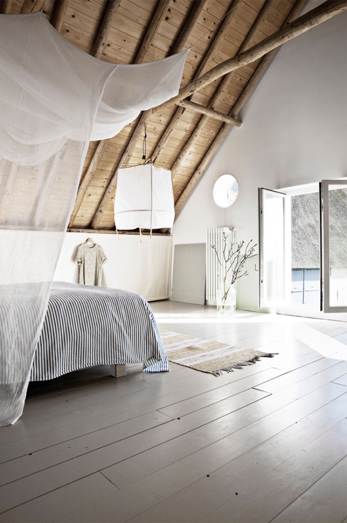 amenagement combles, chambre à coucher aux murs blancs avec plafond de bois clair et poutres de bois décoratives