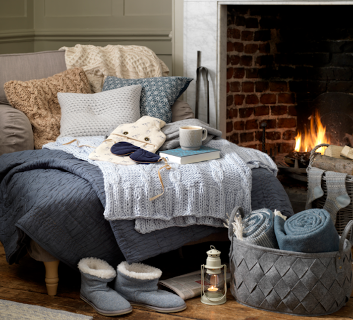 deco d hiver cosy, textiles, couvertures jetés, plaids et coussins sur un canapé gris cosy, pantoufles hiver, panier rangement de textiles, parquet bois brut