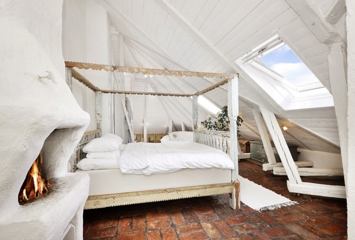 amenagement grenier, chambre à coucher au grenier avec cheminée blanche et cadre de lit en bois