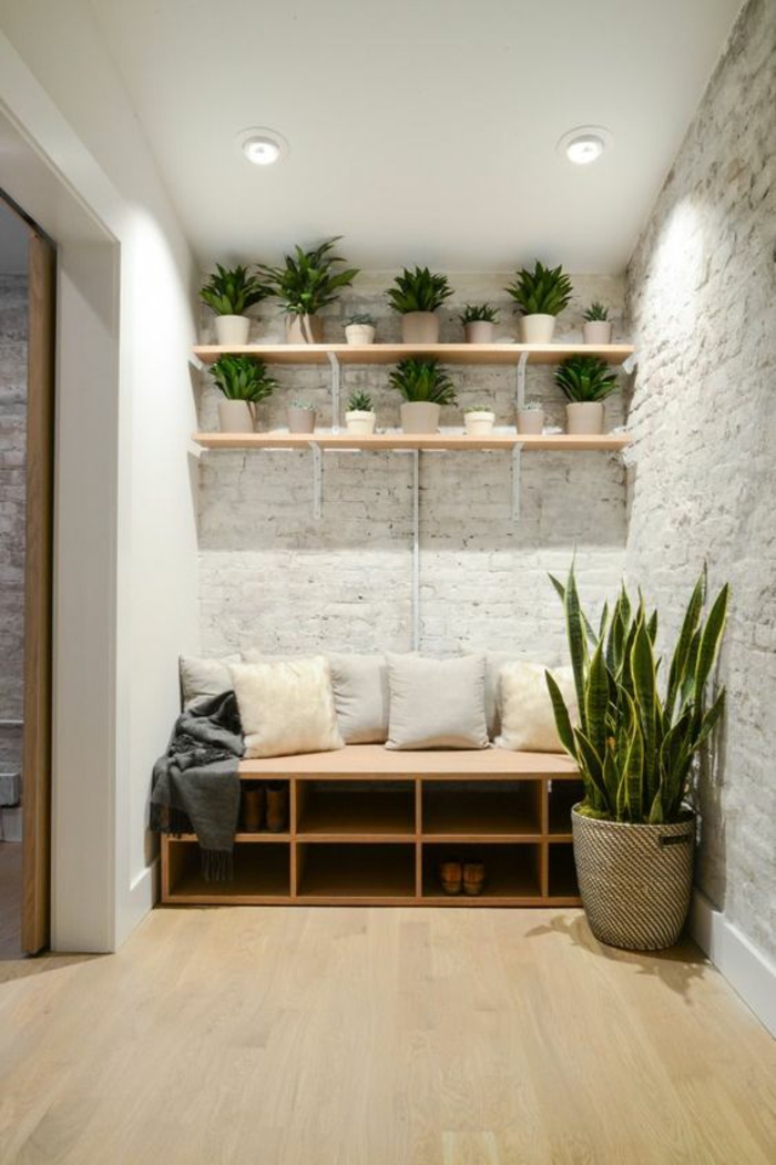 quelle couleur pour un couloir, murs en briques blanches, parquet beige en bois PVC, plafond blanc, étagères en bois clair, grande corbeille en style ethno tressée avec grande plante verte exotique 