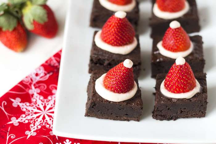 recette de brownies, dessert de noel facile chocolat avec des chapeaux en fraises et crème blanche