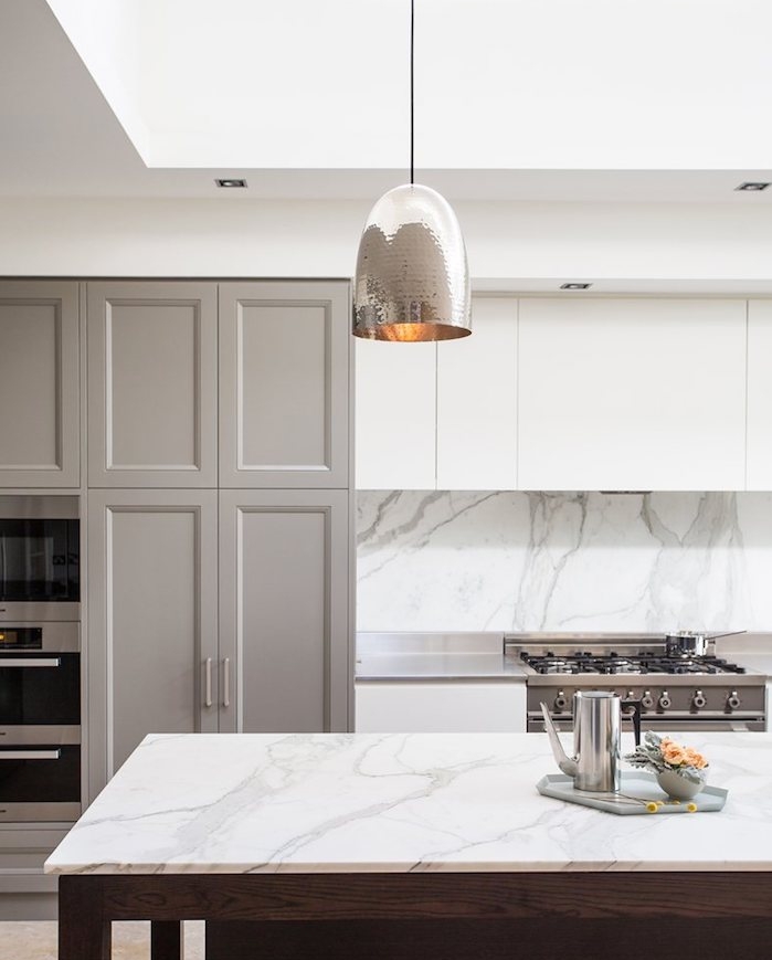 façade cuisine couleur grege, plan de travail ilot central et crédence marbre, suspension grise, meuble haut et bas blanc