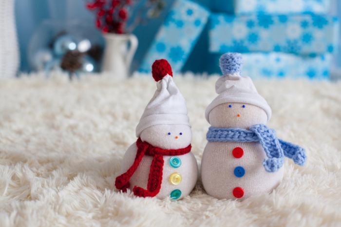 comment faire un bonhomme, décoration de Noël avec tapis blanc moelleux et boîtes de cadeaux bleues à flocons de neige 