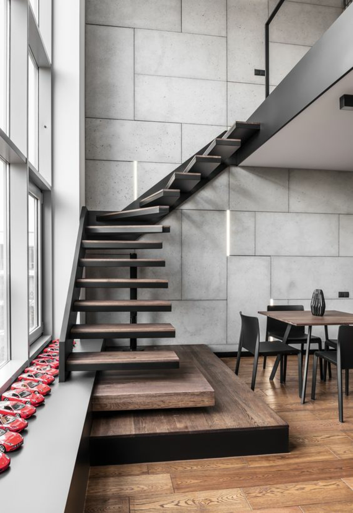 escalier bois escalier moderne avec structure portante en métal noir, maison aménagée en style industriel, espaces ouverts qui se fondent les uns dans les autres, murs en grands carreaux de pierre blanche