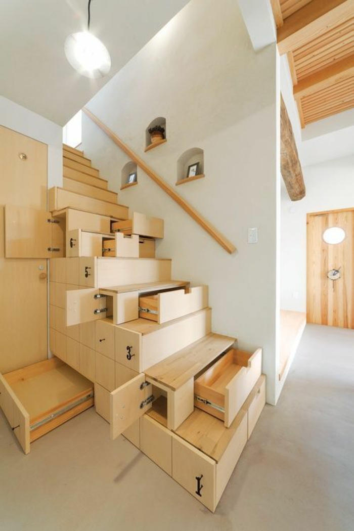 escalier bois clair, avec des marches qui contiennent des tiroirs dans leur intérieur, poignée simple et minimaliste, sans ornements, en bois clair, sol avec des carrelages blancs, plafond décoré avec faux plafond de poutres en bois clair