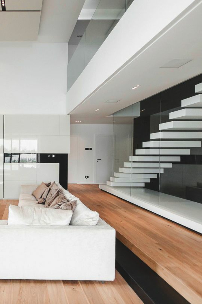 escalier design tout blanc, recouvert entièrement de verre, joli effet d'ascension, canapé modulaire blanc avec des coussins en poudre de rose et des coussins blancs