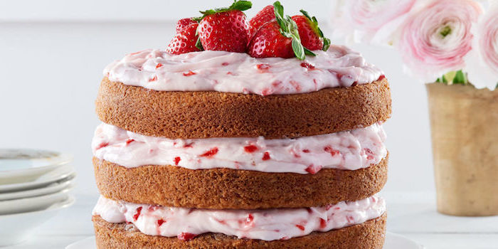 exemple de recette de glacage de fromage à la crème et fraises pour faire un gâteau à trois étages, décoration de fraises rouges dessus