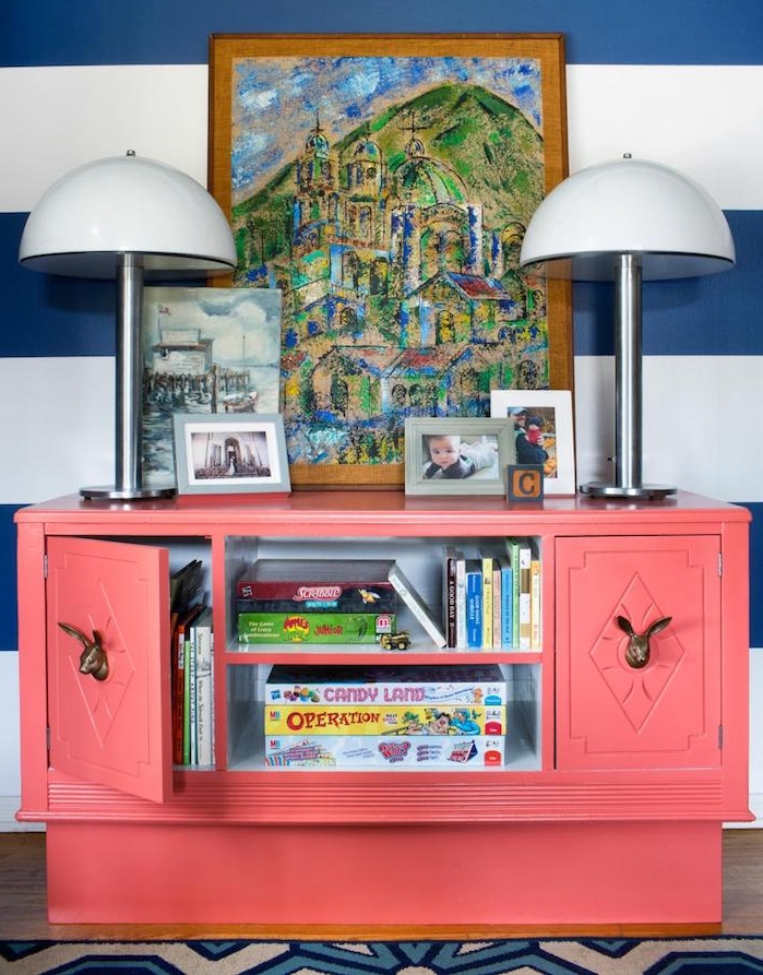 idée pour peindre un meuble ancien, un rangement vintage repeint en saumon, mur à rayures bleues et blanches et cadre, tableau peinture multicolore de paysage montagrnard