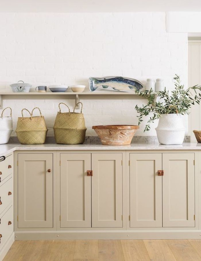 amenagement cuisine avec façade couleur taupe clair, plan de travail marbre, paniers de rangement rustiques, étagère ouverte avec vaisselle