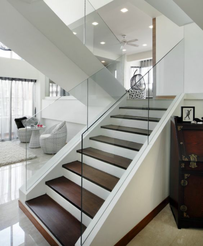 escalier bois en couleur cerise et blanc, escalier moderne avec garde corps en verre transparent, sol avec dalles en couleur ivoire, meubles en rotin peints en blanc avec table en rotin en blanc