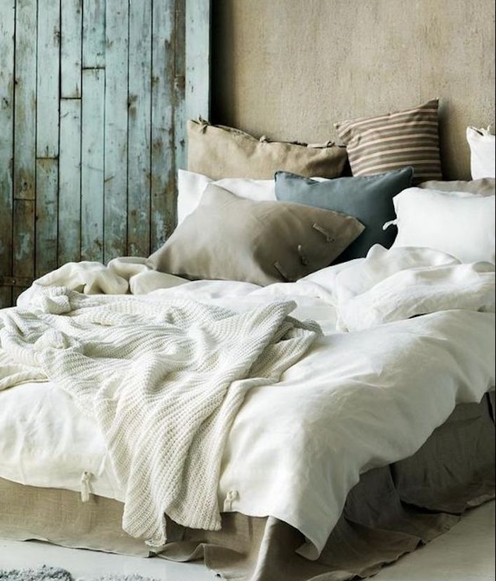 gris souris peinture sur les murs d une chambre à coucher en gris et blanc, plaid blanc tricot, coussins grege, bleu et marron, porte usée
