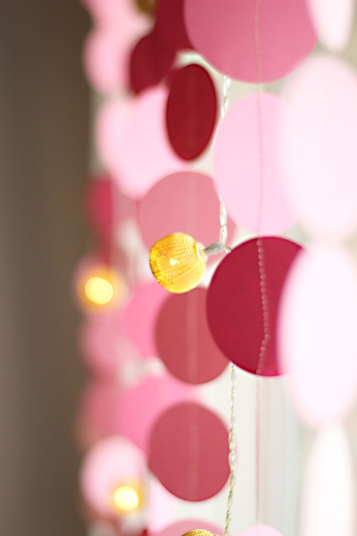activité créative, modèle de guirlande fait main à motifs cercles de papier rose et fil blanc