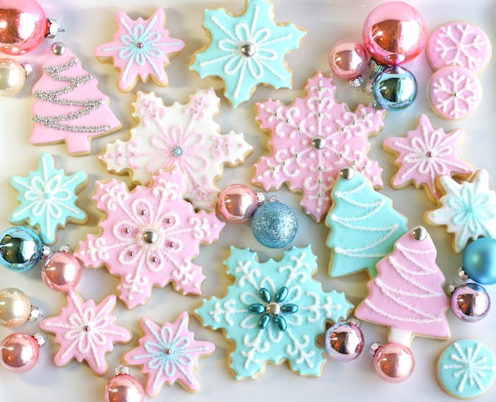 biscuit de noel recette, biscuits en forme de flacon de neige et arbres de nel, comment faire un glacage, couleur rose, blanche et bleue, deco boules de noel