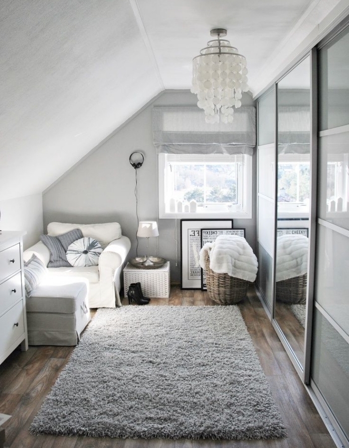 décoration cozy en style scandinave dans une petite chambre au grenier avec tapis moelleux et fauteuil convertible