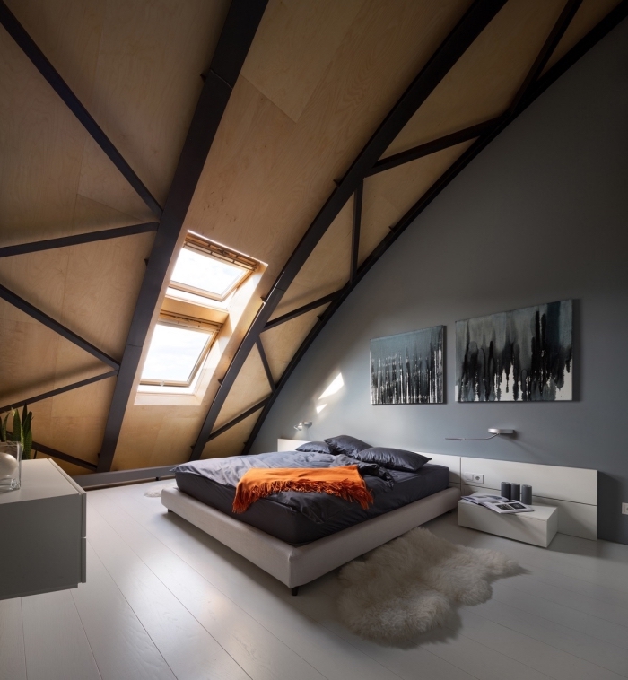 chambre a coucher au grenier avec murs en gris et plafond en bois et noir, cadre de lit blanc et meubles sans poignées