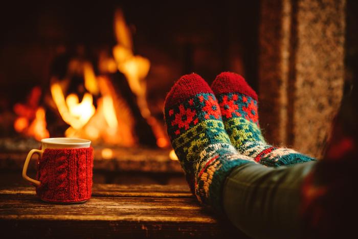idee deco cocooning hiver, cheminée romantique, chaussettes vert et rouge, tasse de cadé, décor en bois, style hygge hiver