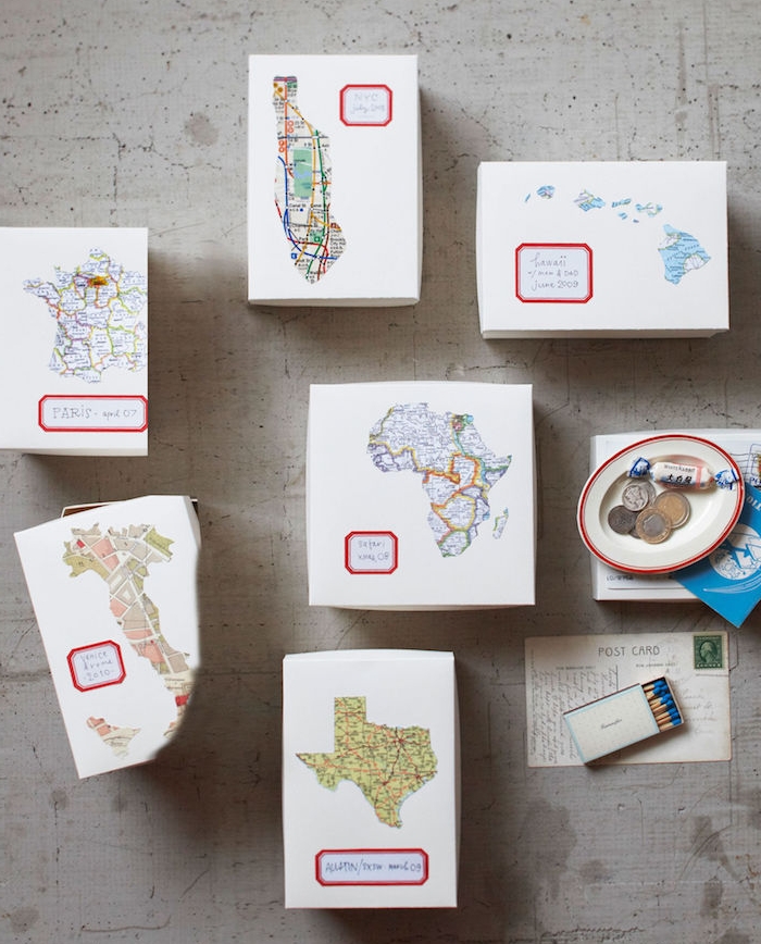 cadeau anniversaire femme, des boites en papier blanches décorés de cartes des continents pour recueillir des souvenirs de voyages