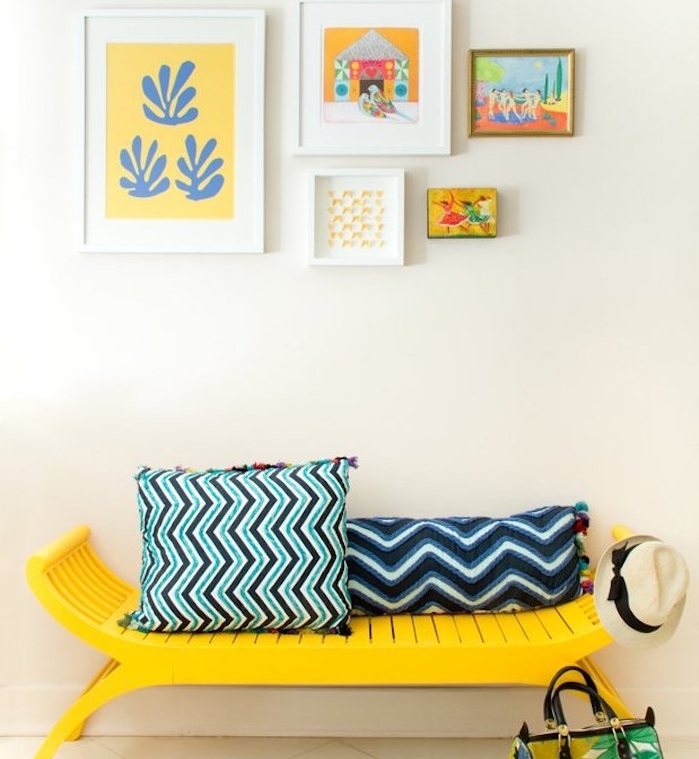 comment peindre un meuble en jaune, un banc customisé et coussins bleu et noir à motifs géométriques, deco de cadres sur le mur