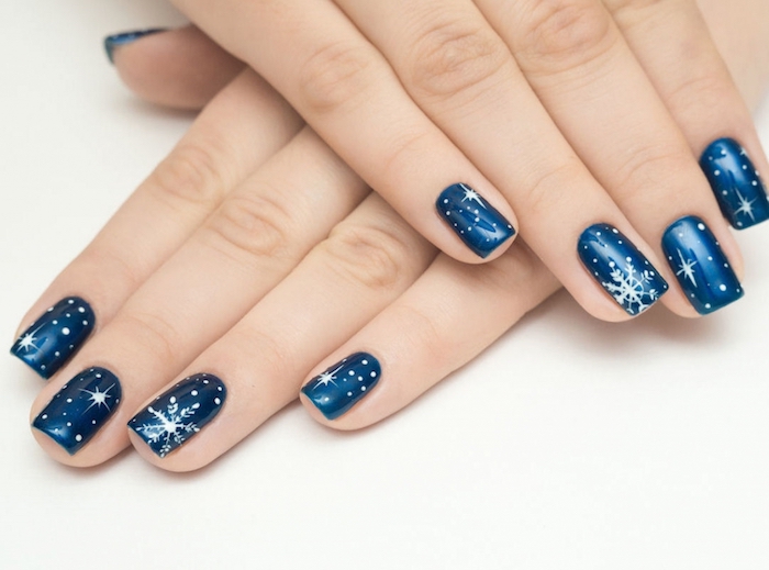 deco ongle noel en venis à ongles couleur bleu foncé et motif flacon de neige et étoiles, idée simple