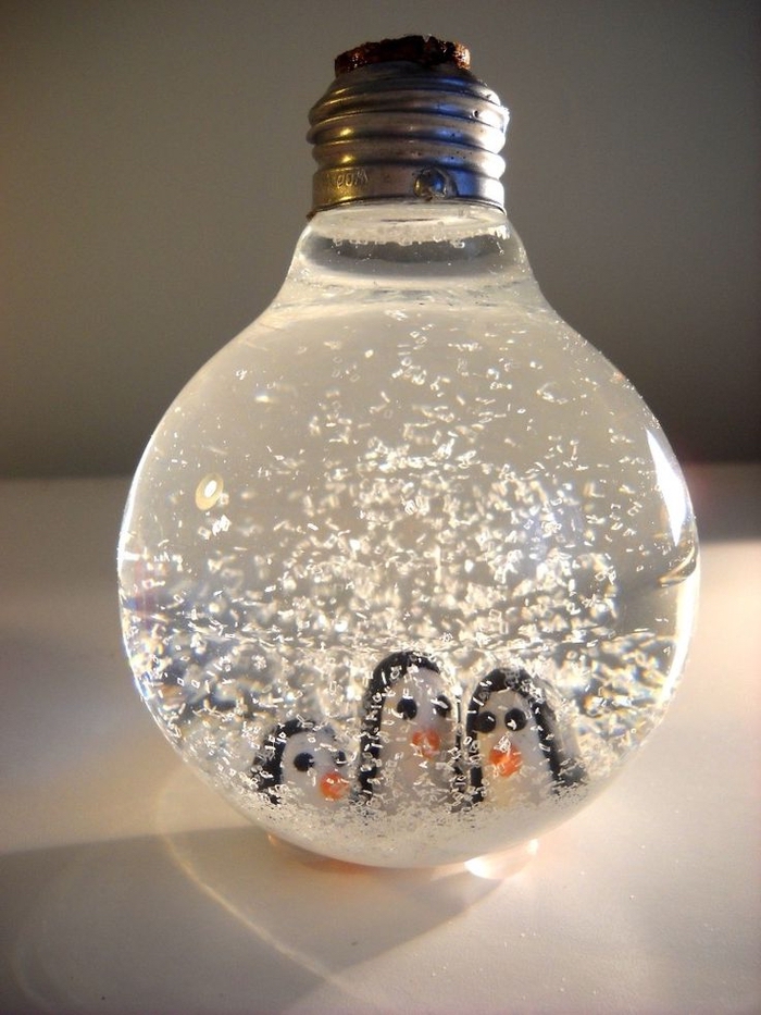 bricolage de recyclage original avec une ampoule usagée transformée en boule a neige pingouins
