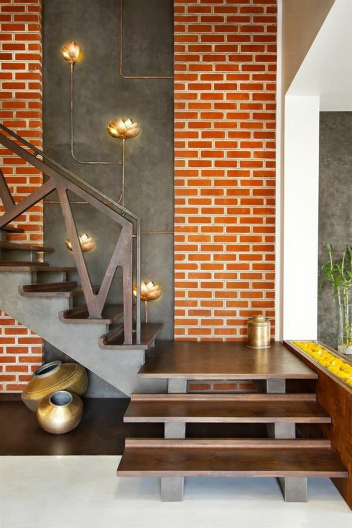 idée entrée mur en briques oranges et escalier avec des marches en métal couleur bronze, éléments déco avec des fleurs en métal bronze