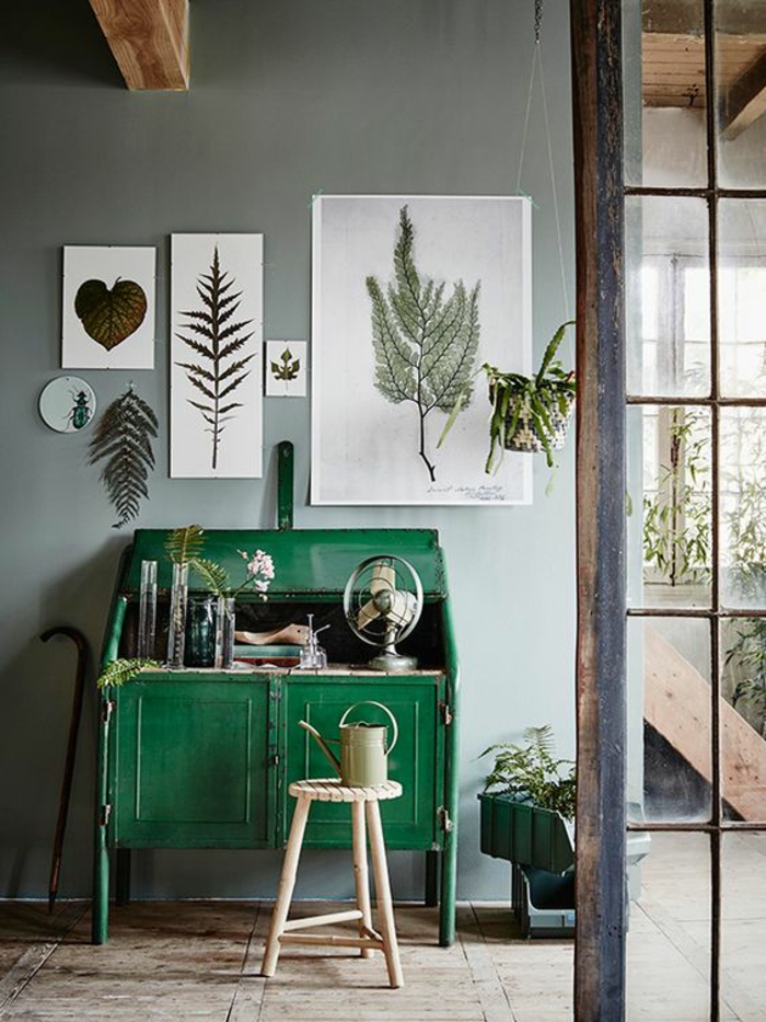 comment decorer un couloir avec meuble vintage peint en vert vif, tabouret en bois clair en forme ronde, cinq photos d'herbes et de plantes au mur, peint en gris, parquet en bois clair, des poutres en bois rude au plafond, style maison de campagne