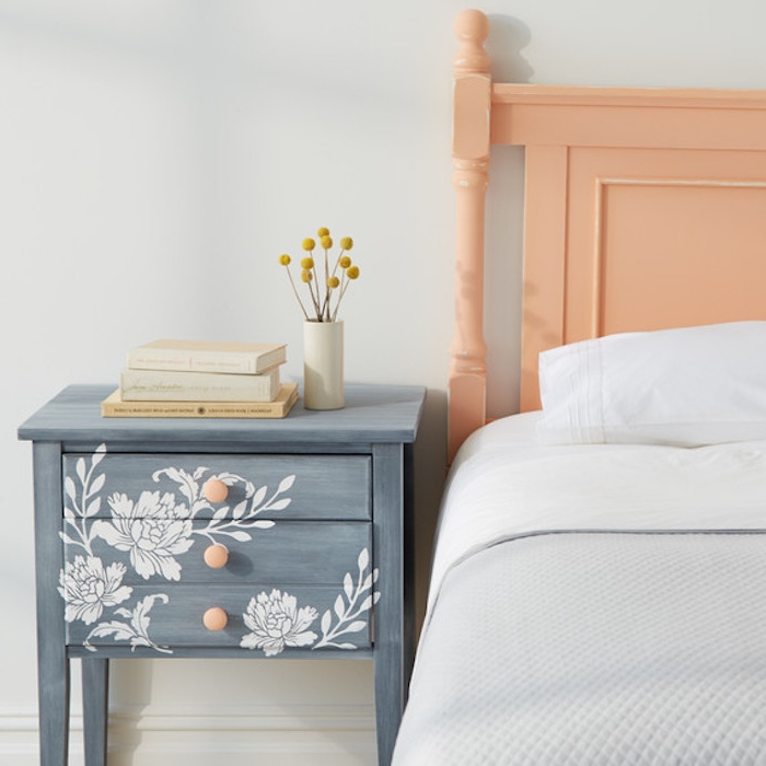peindre un meuble en bois, idée de table de nuit repeinte en gris et motifs floraux blancs décorés au pochoir, linge de lit blanc