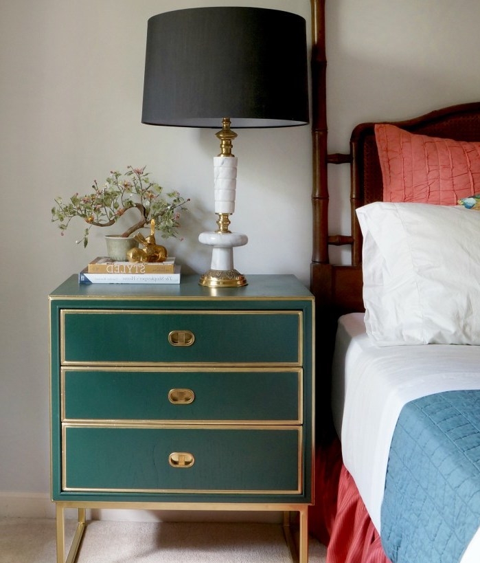 table de nuit avec rangements repeinte en vert émeraude, linge de lit blanc, bleue et rouge, lampe de nuit noire à pied doré, tapis beige