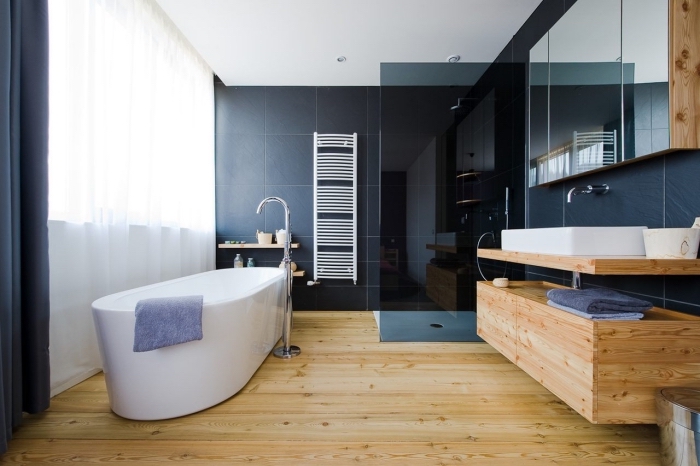 idee deco salle de bain, pièce avec plancher en bois et carrelage en noir, grande fenêtre avec rideaux noirs et voiles blanches