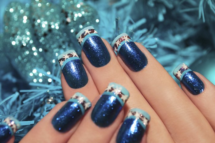 exemple de modele nail art à vernis à ongles en paillettes bleues, bout bleu clair, ligne noire et étoiles blanches