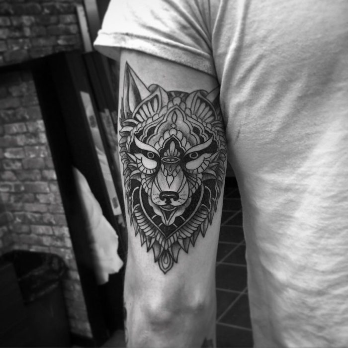 tatouage homme, art corporel en encre sur main à design loup aux motifs ethniques