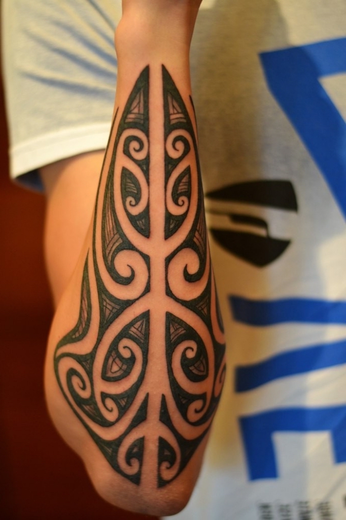 tatouage tribal homme, tattoo symbolique sur le bras aux motifs ethniques et volutes