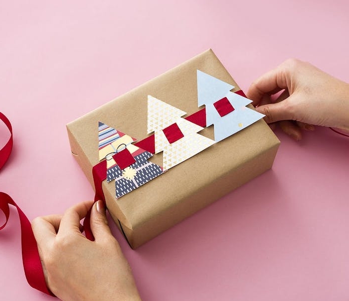 boite emballage cadeau pour noel en papier kraft et sapins de noel en carton colorés avec un ruban rouge passé à travers
