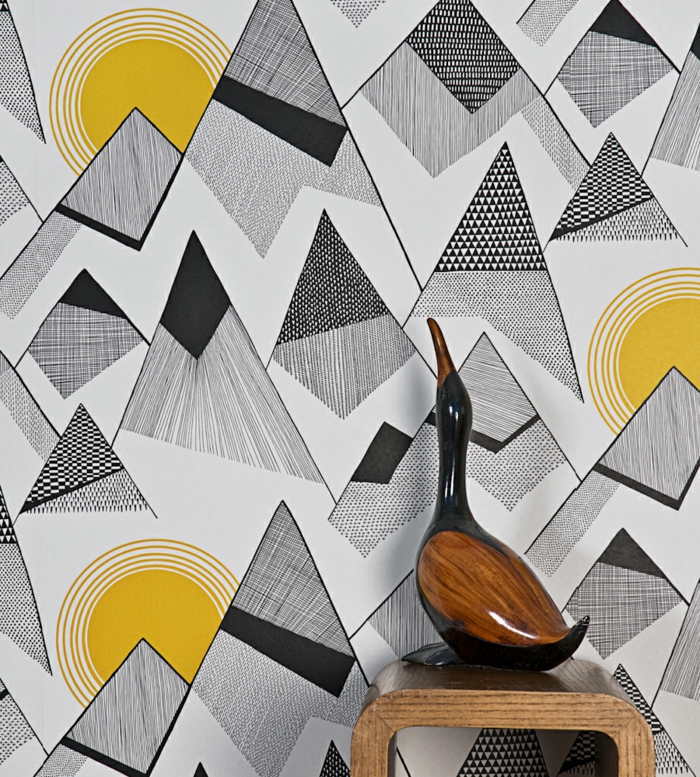 papier peint intissé, formes géométriques triangulaires en noir, avec des soleils brillants, mur d'entrée, canard décoratif en bois laqué sur une petite table 