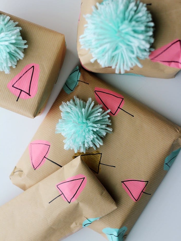 boite emballage cadeau en papier kraft avec silhouettes de sapins de noel dessin enfant et pompons bleus