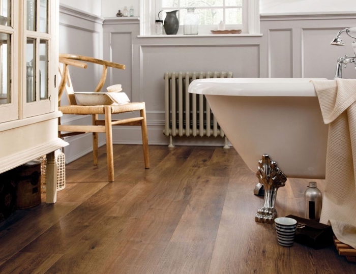 salle de bain avec parquet, meubles de bain style vintage en bois, chaise en bois et armoire en bois et verre clair