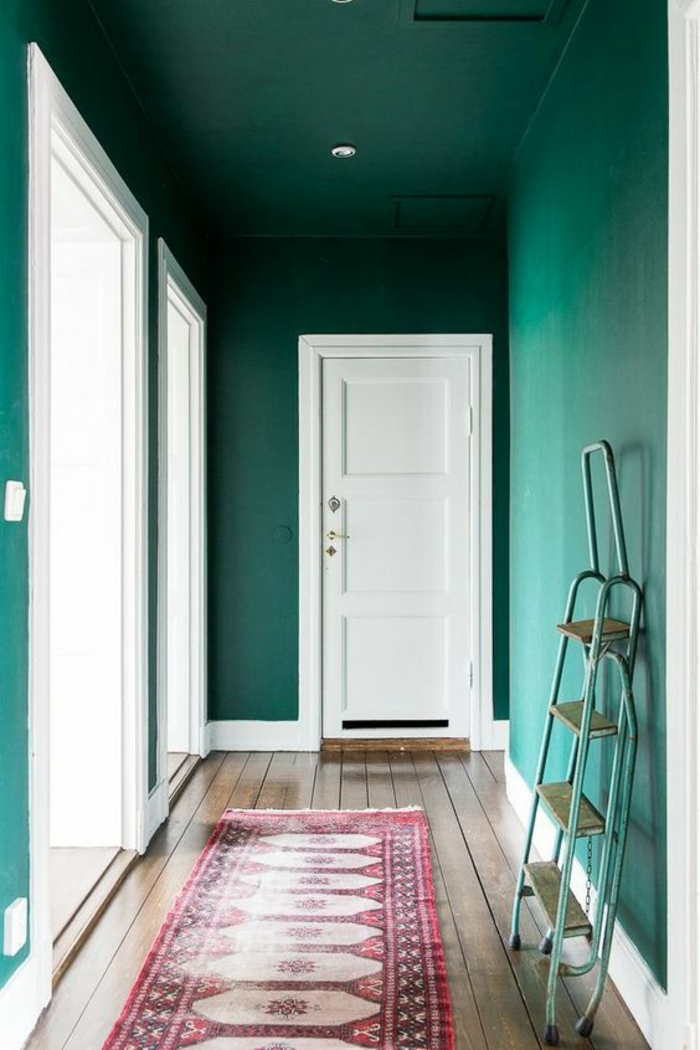 deco couloir peinture bleu canard portes blanches, tapis rectangulaire en rose et blanc, posé sur un parquet en bois en couleur beige 